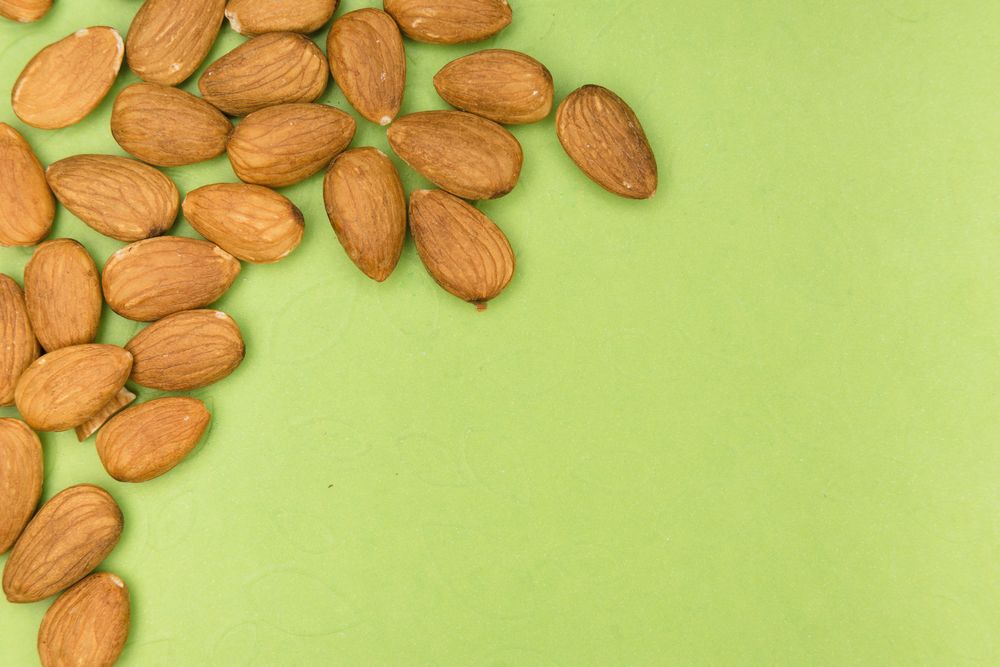 Amandes disposées sur un fond vert tendre
