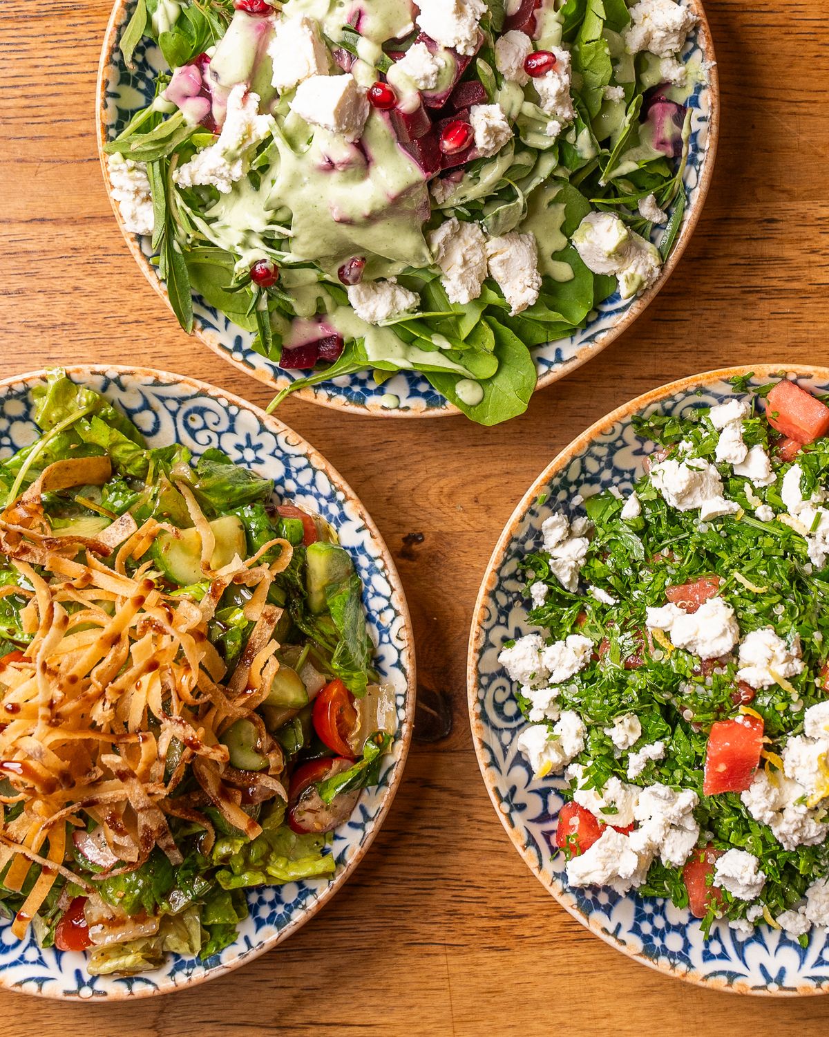 Grandes salades composées dans des assiettes colorées